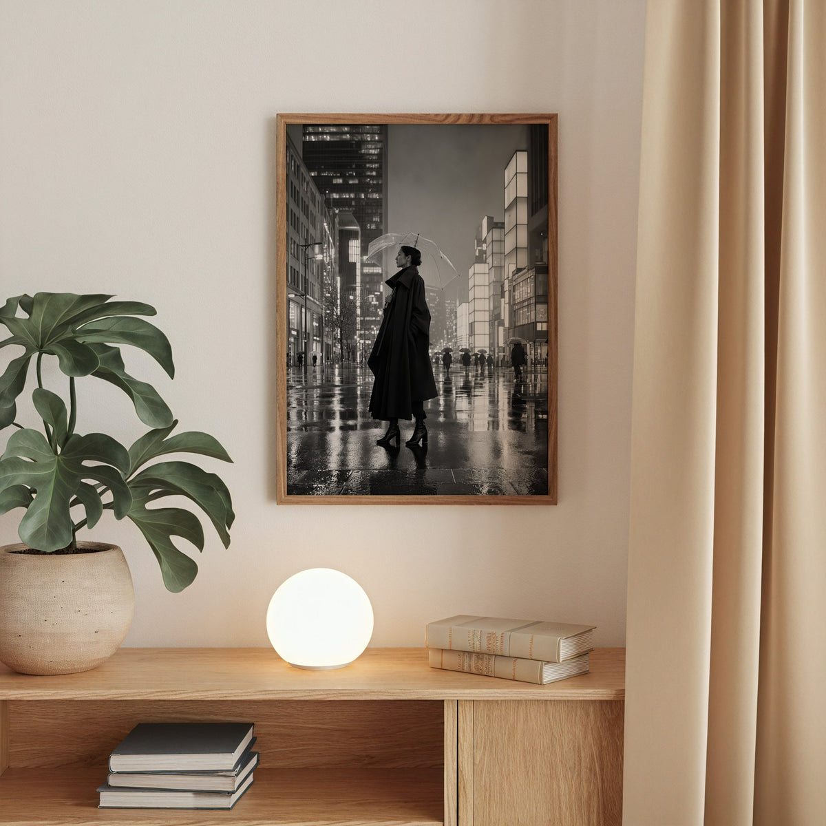 Woman with clear umbrella on rainy night street print in a walnut frame above an oak cabinet with a glowing globe lamp