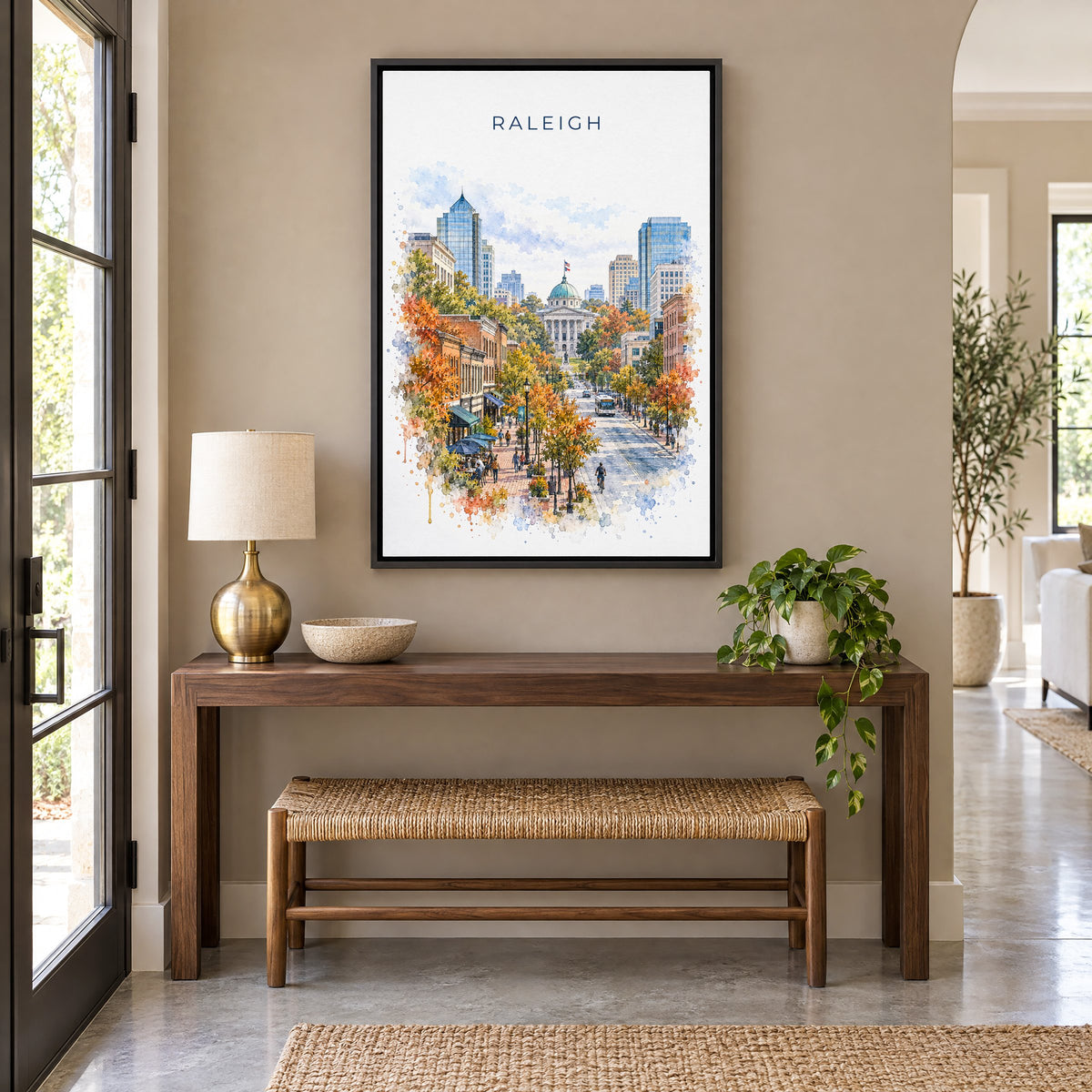 Raleigh watercolor print as a black floater canvas above a walnut console and woven bench in an entryway