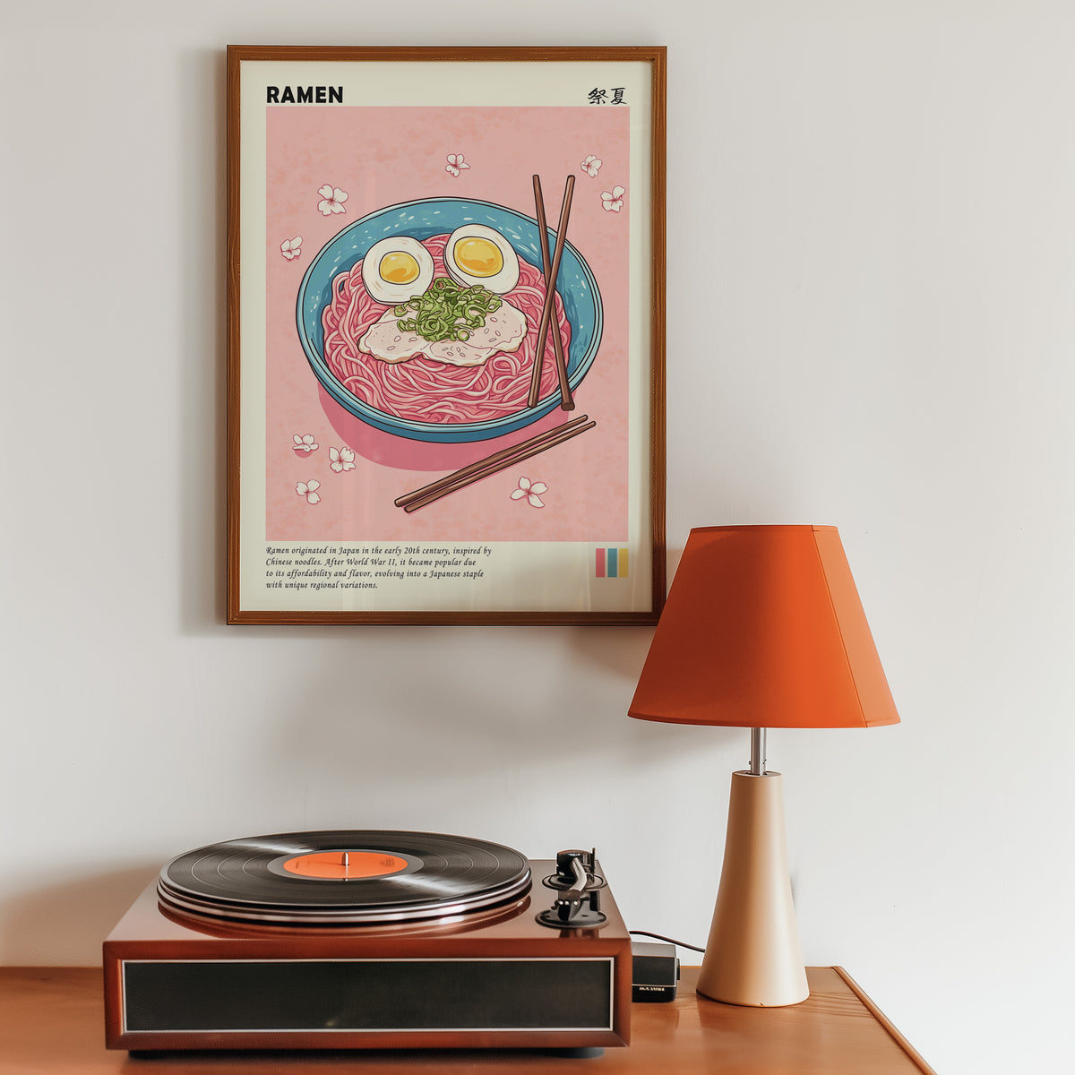 Turquoise ramen bowl with pink noodles print in a walnut frame above a sideboard with a record player