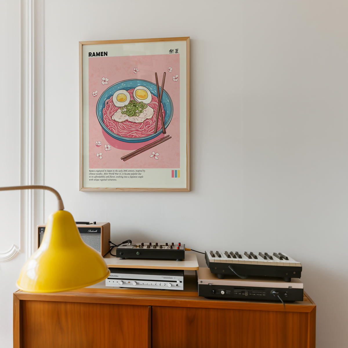 Turquoise ramen bowl with pink noodles print in an oak frame above a teak sideboard with vintage hi-fi
