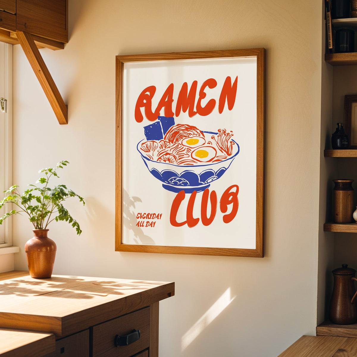 Ramen Club print in a walnut frame on a cream kitchen wall above the island