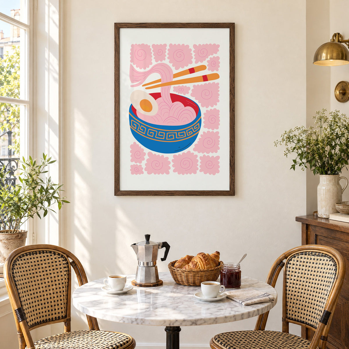 ramen noodles chopsticks pink swirl print in a walnut frame above a marble bistro table with croissants and rattan chairs