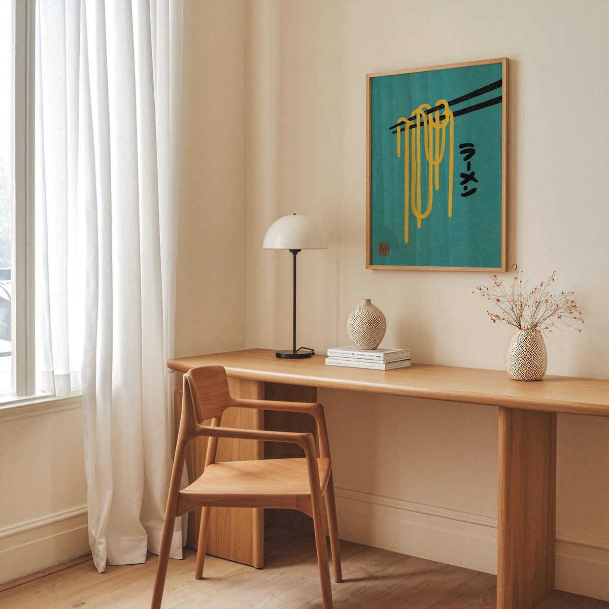 ramen noodles and chopsticks on teal print in an oak frame above a long oak desk with a white dome lamp and woven vases