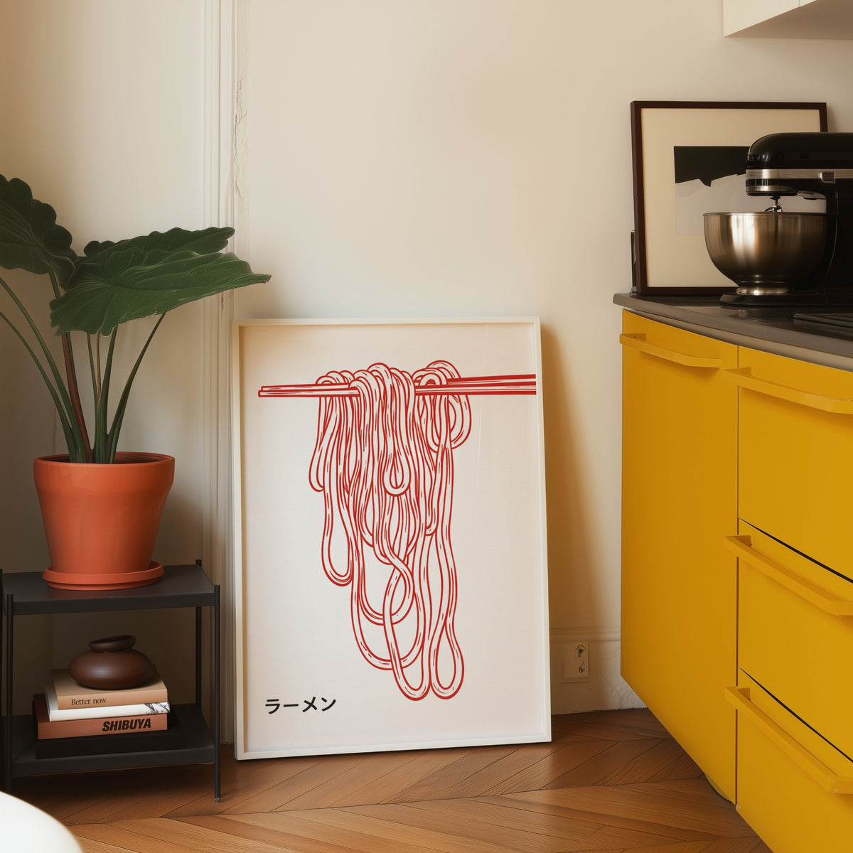 Ramen noodles print in a white frame on parquet beside a bright yellow kitchen