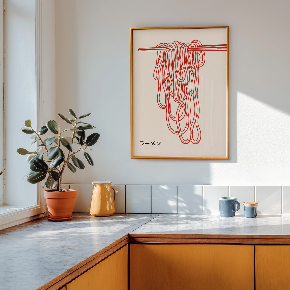 Ramen noodles print in a gold frame above a marble counter with a yellow ceramic jug