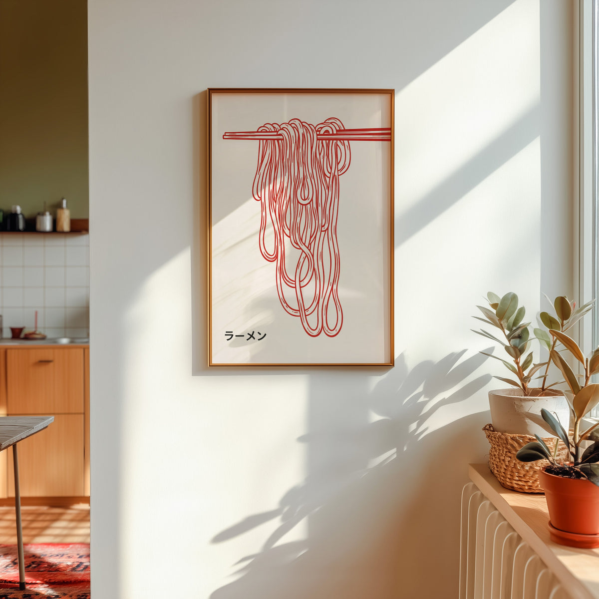 Ramen noodles print in a gold frame in sunlight with plants and a kitchen beyond