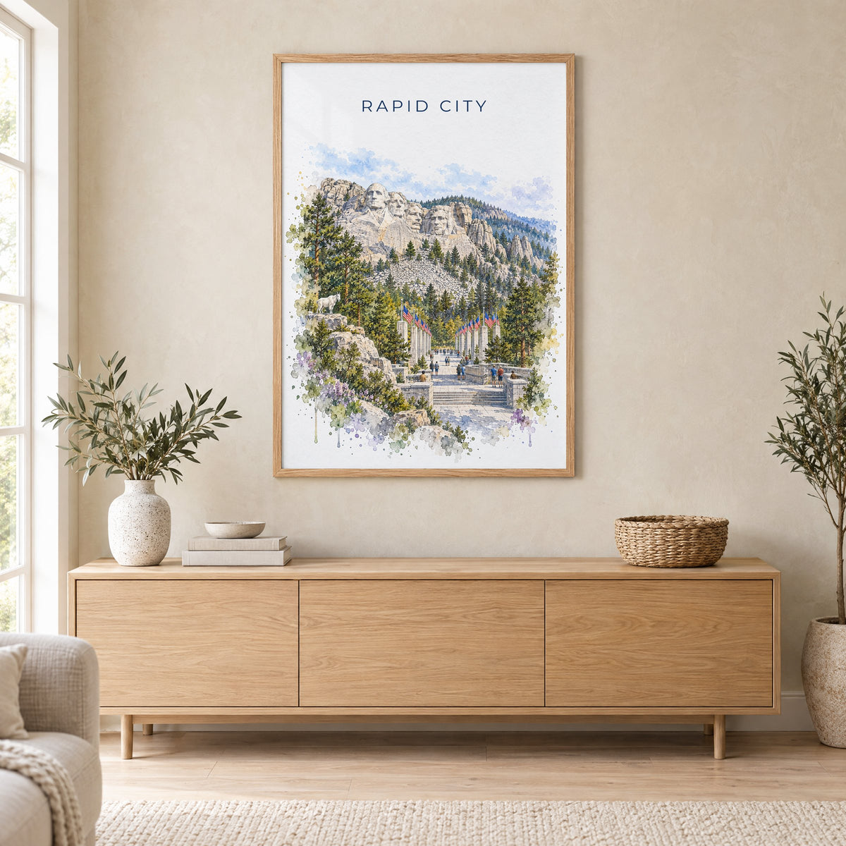 Rapid City watercolor print in an oak frame above a light wood sideboard in a Scandinavian living room