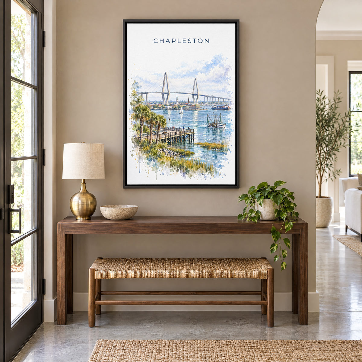 Ravenel Bridge Charleston watercolor print as a black floater canvas above a walnut console and woven bench in an entryway