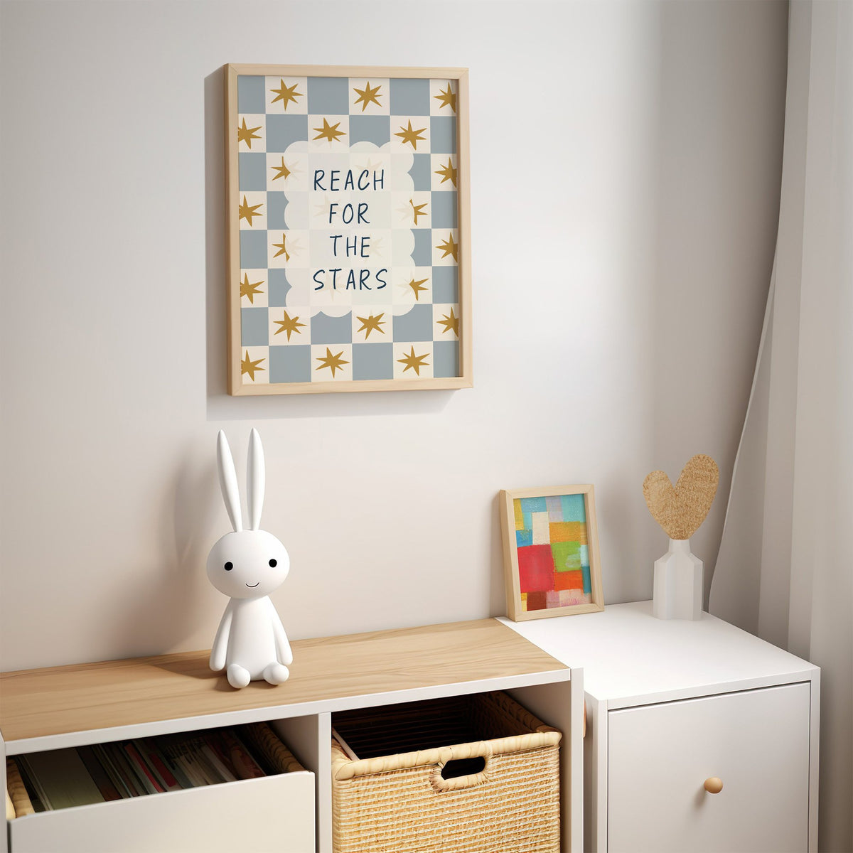Reach for the stars cloud nursery print in an oak frame above a kids cubby shelf with a woven basket and bunny lamp