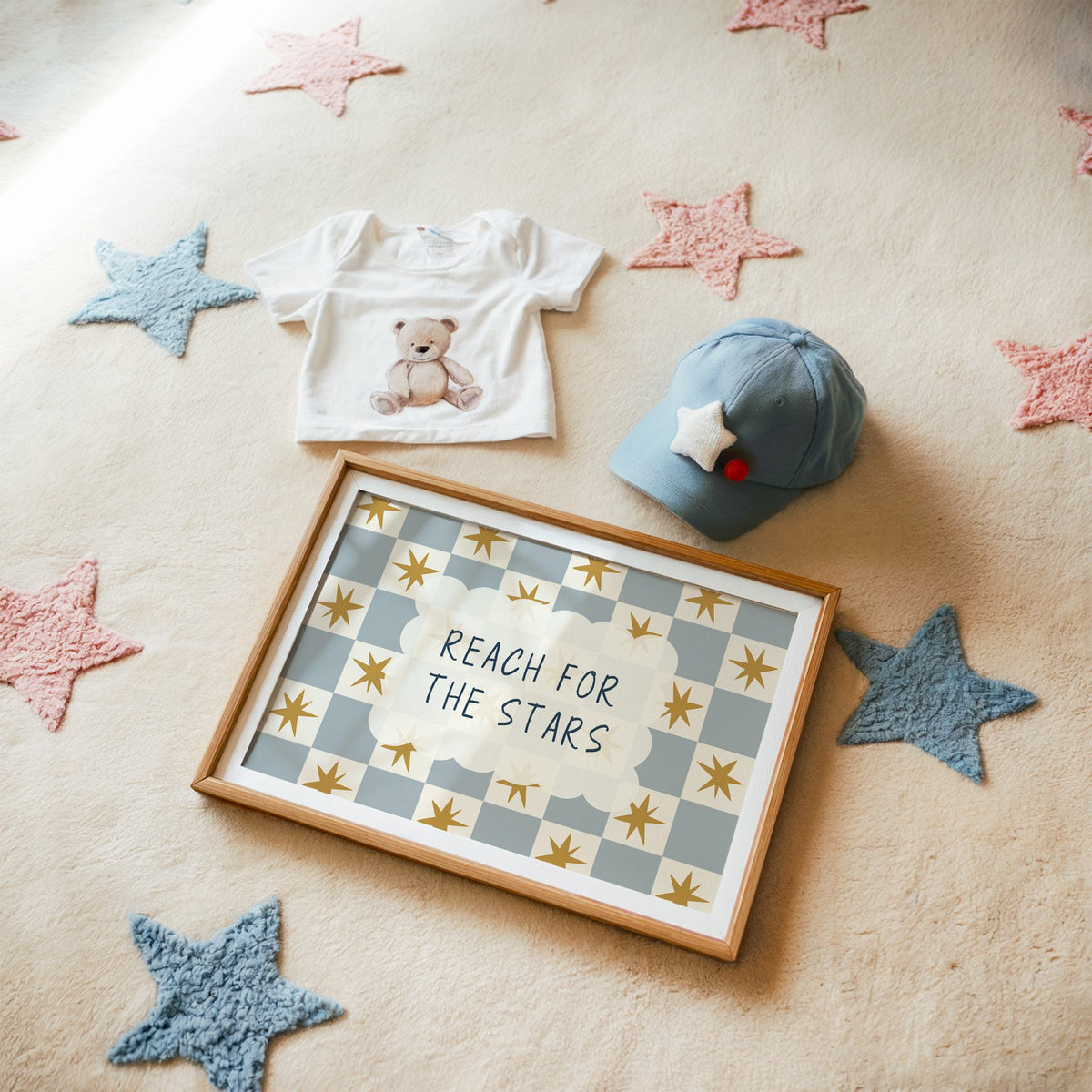 Landscape reach for the stars cloud nursery print in a matted oak frame on a star rug with a baby tee
