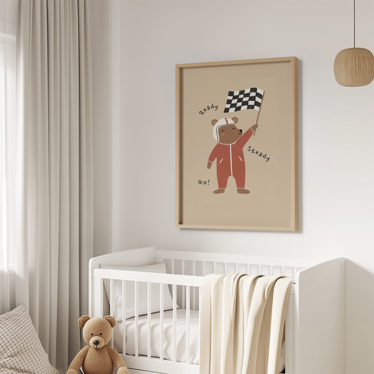 Ready steady go racing bear nursery print in an oak frame above a white crib with a teddy bear