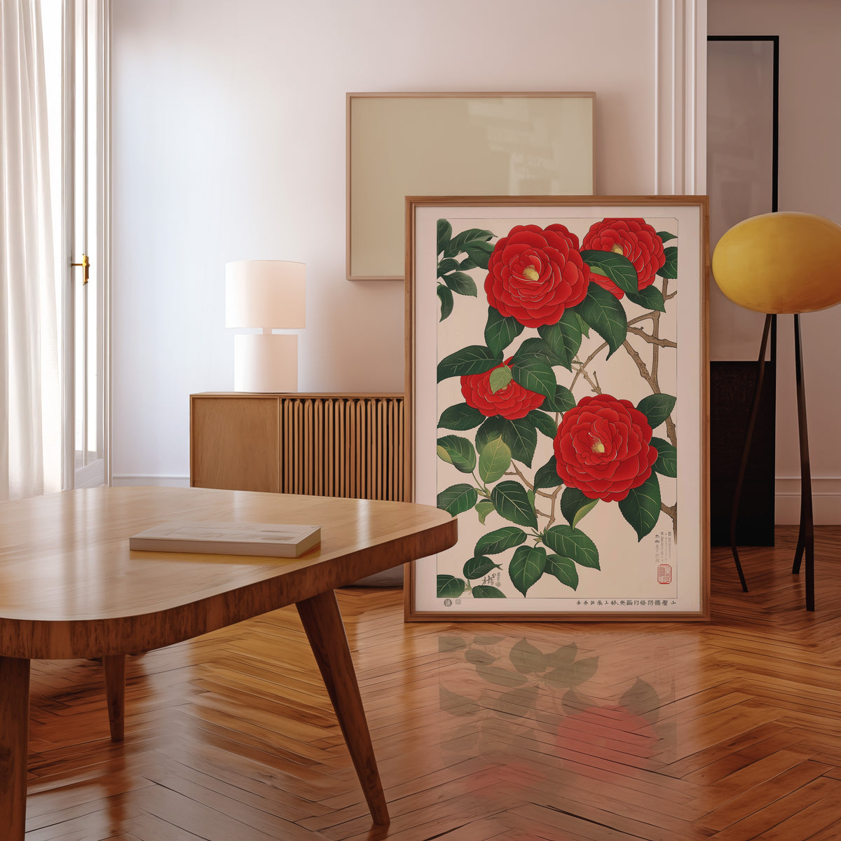 Red camellia woodblock-style print in a walnut frame leaning in a mid-century living room