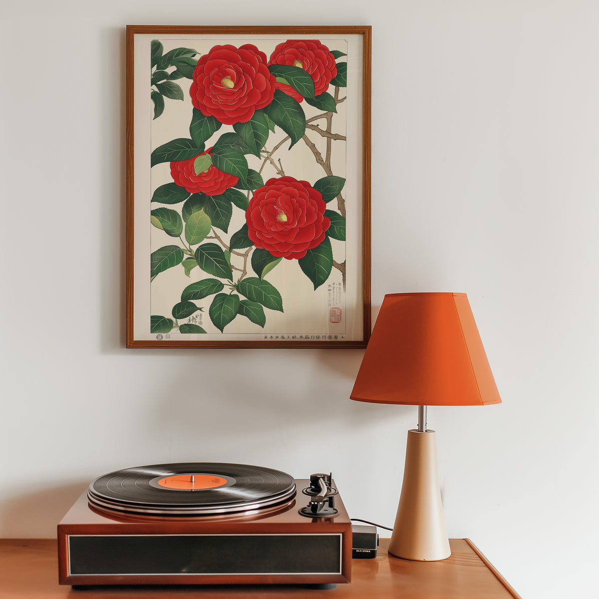 Red camellia woodblock-style print in a walnut frame above a sideboard with a record player