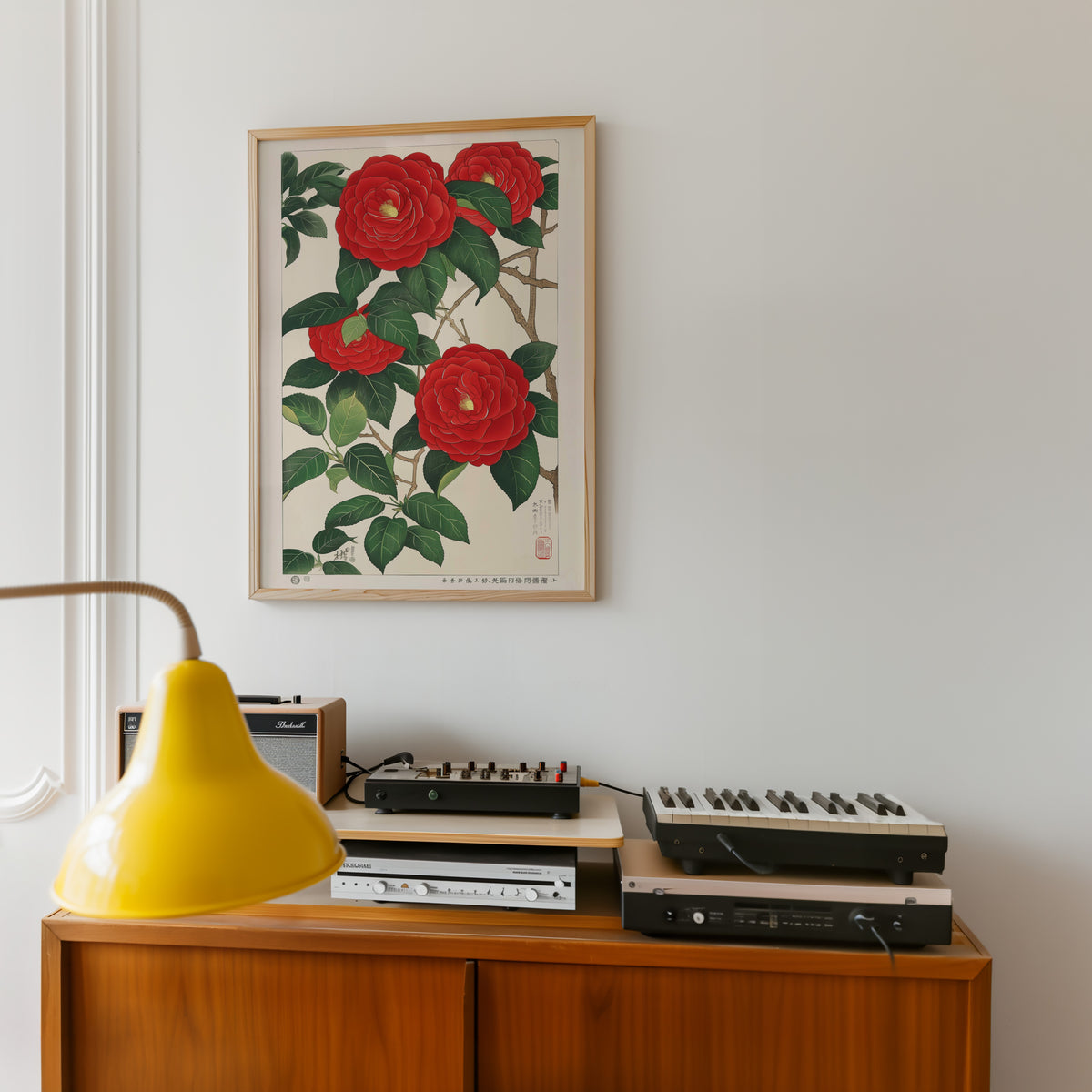 Red camellia woodblock-style print in an oak frame above a teak sideboard with vintage hi-fi
