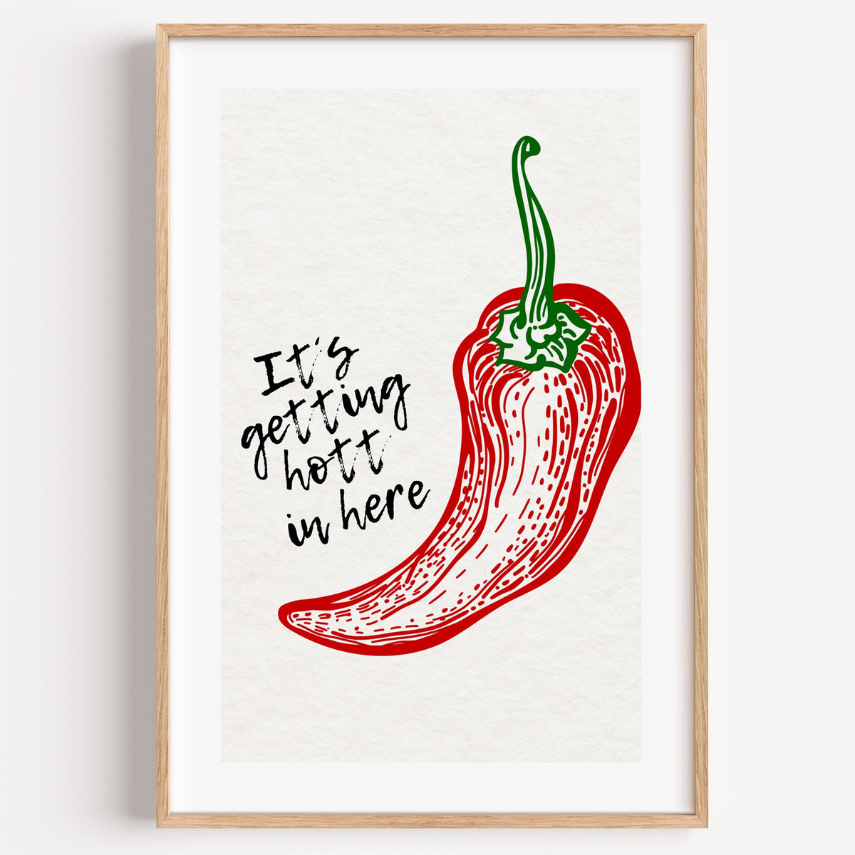 It's getting hott red chili engraving print in a light oak frame on a plain white wall