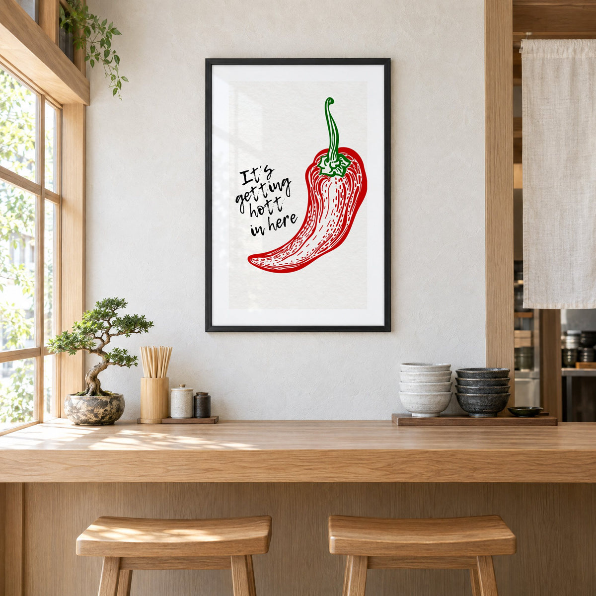It's getting hott red chili engraving print in a black frame above a light wood ramen counter with stools and stacked bowls