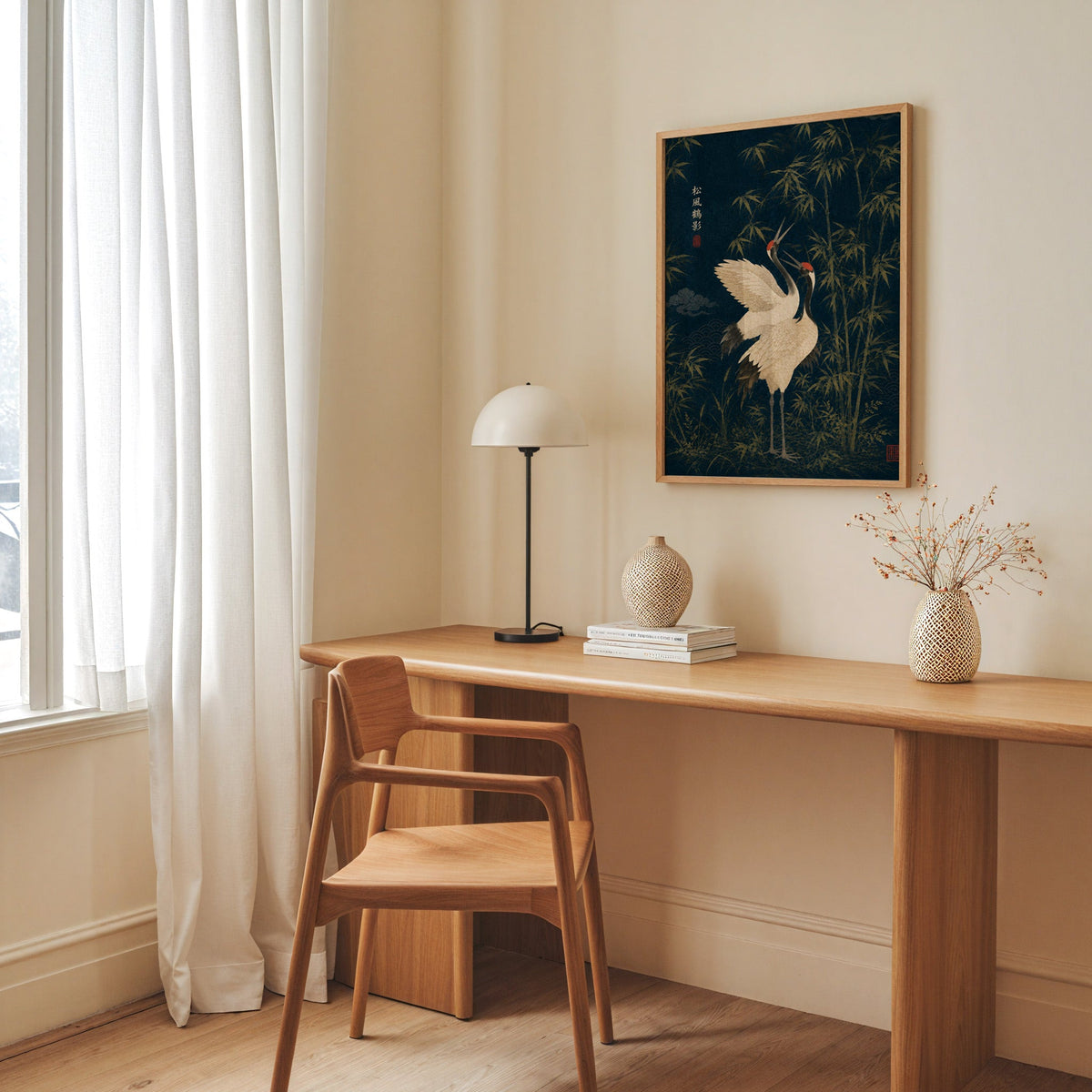 red-crowned cranes and bamboo on navy print in an oak frame above a long oak desk with a white dome lamp and woven vases