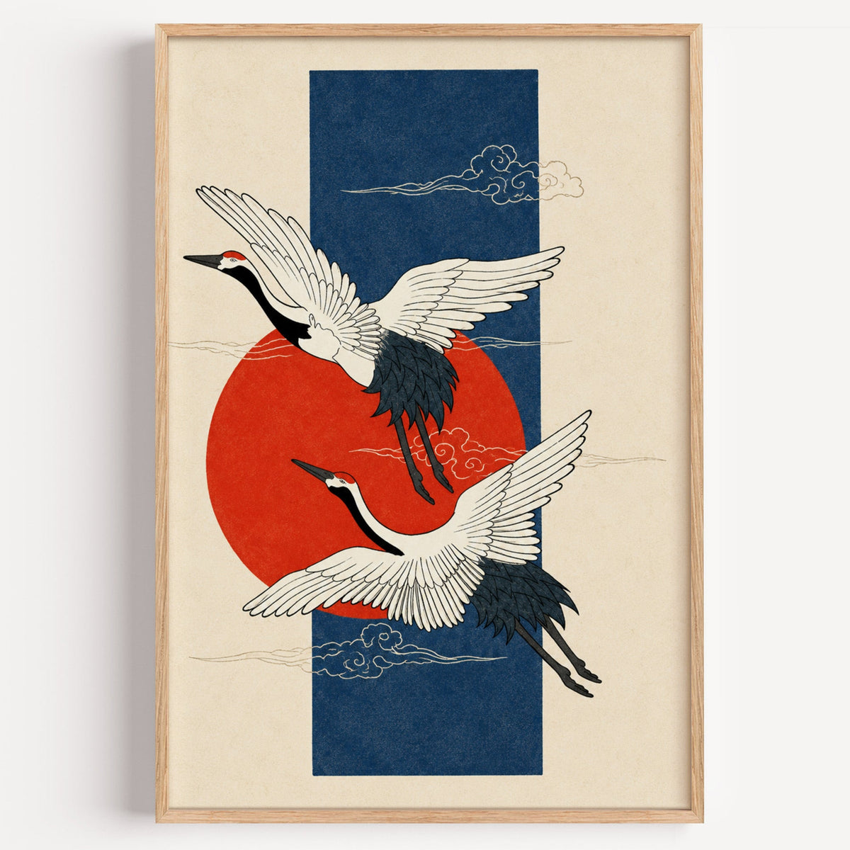 red-crowned cranes on navy with red sun print in a light oak frame on a plain white wall