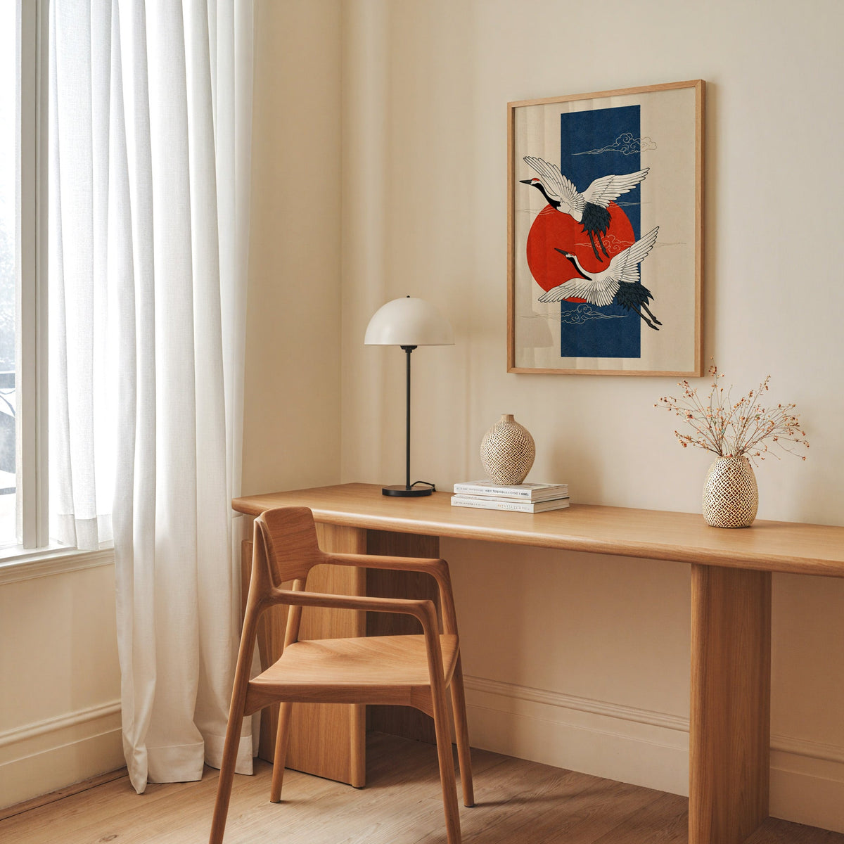 red-crowned cranes on navy with red sun print in an oak frame above a long oak desk with a white dome lamp and woven vases