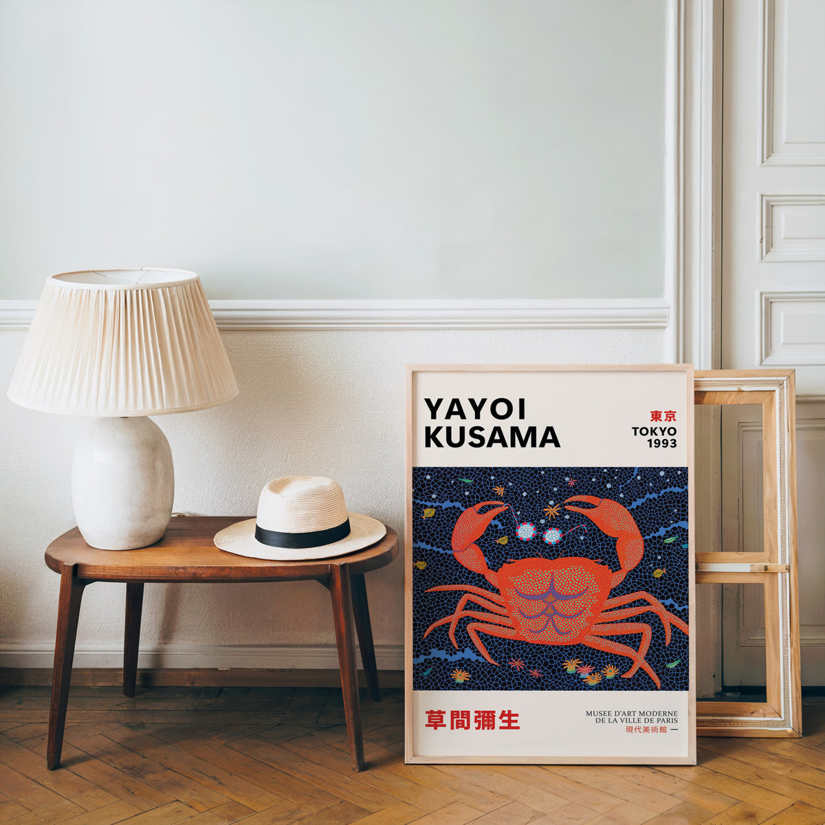 Yayoi Kusama inspired red dotted crab print beside a bench and straw hat