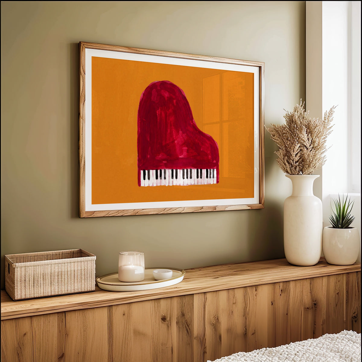 Red grand piano print in an oak frame on an olive green wall above pampas grass