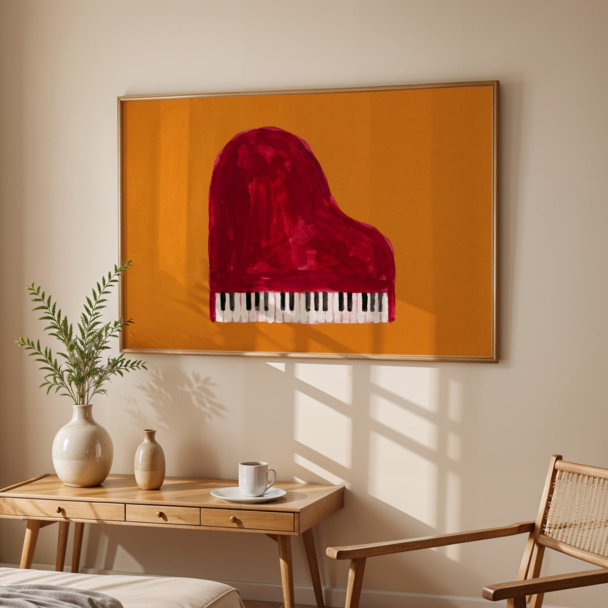 Grand piano from above print in an oak frame above a sunlit desk with a cane chair