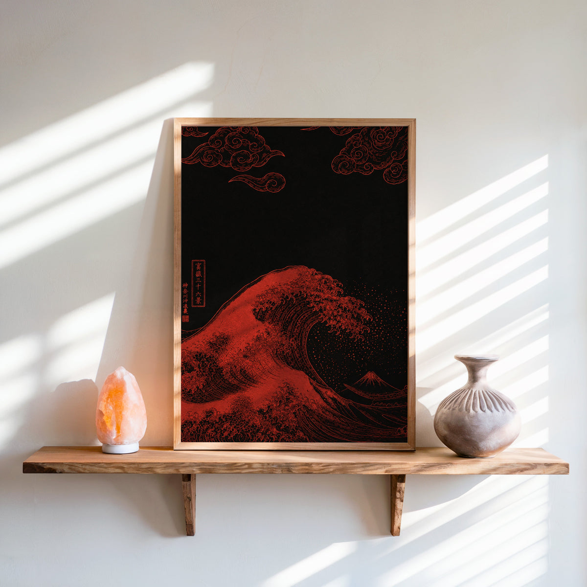 red Great Wave on black print in an oak frame on a live-edge wall shelf with a salt lamp and clay vase