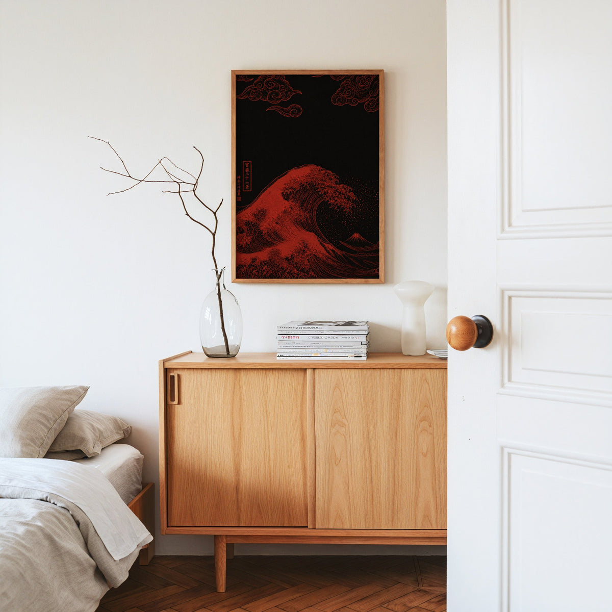 red Great Wave on black print in an oak frame above an oak sideboard in a bedroom with linen bedding