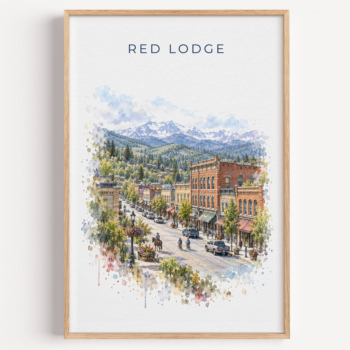 Red Lodge, Montana watercolor print in a light oak frame on a plain white wall