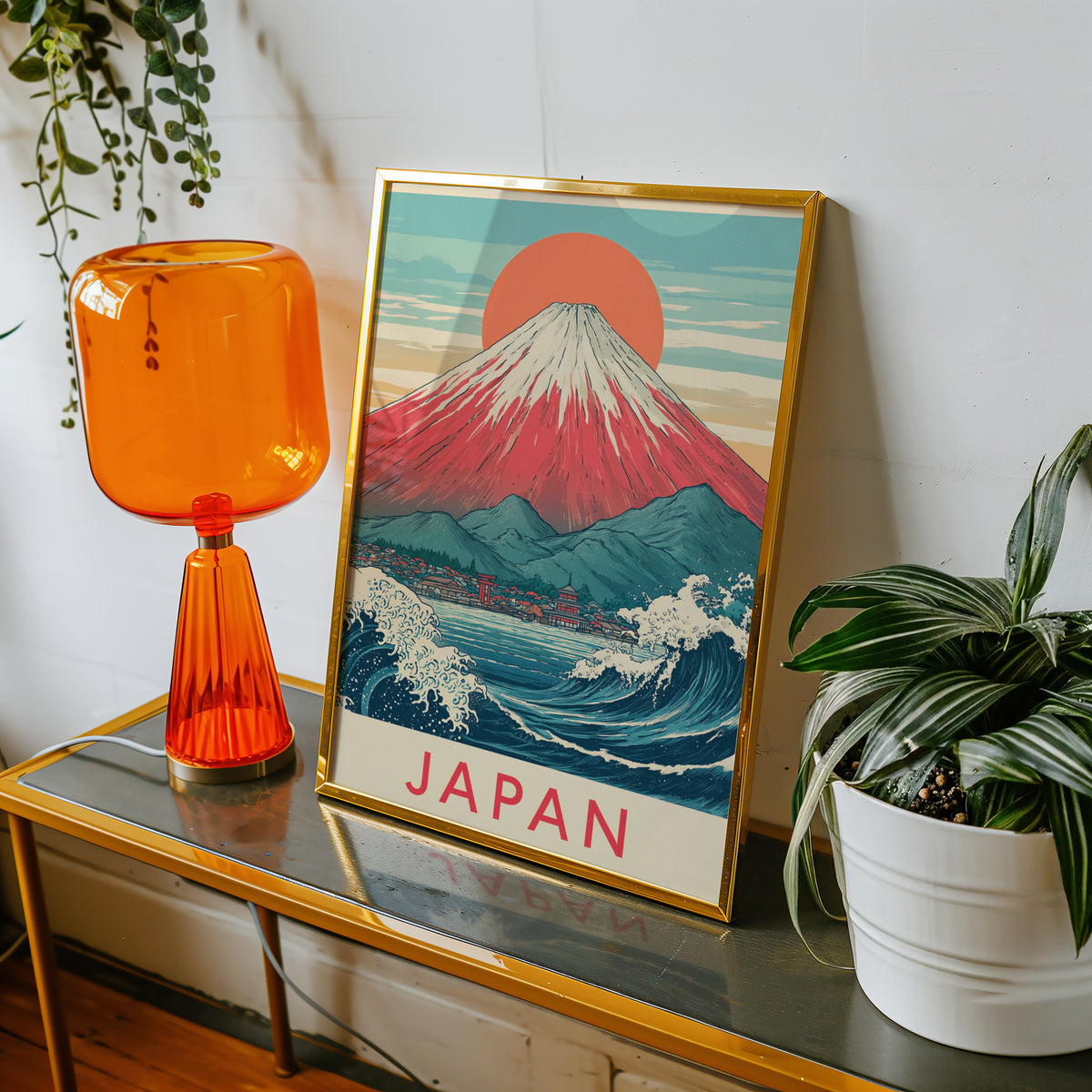 Red Mount Fuji navy wave print shown in a gold frame on a console beside an orange glass lamp