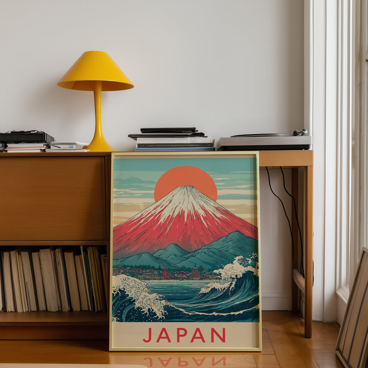 Red Mount Fuji navy wave print shown in a gold frame below a teak desk with a yellow lamp