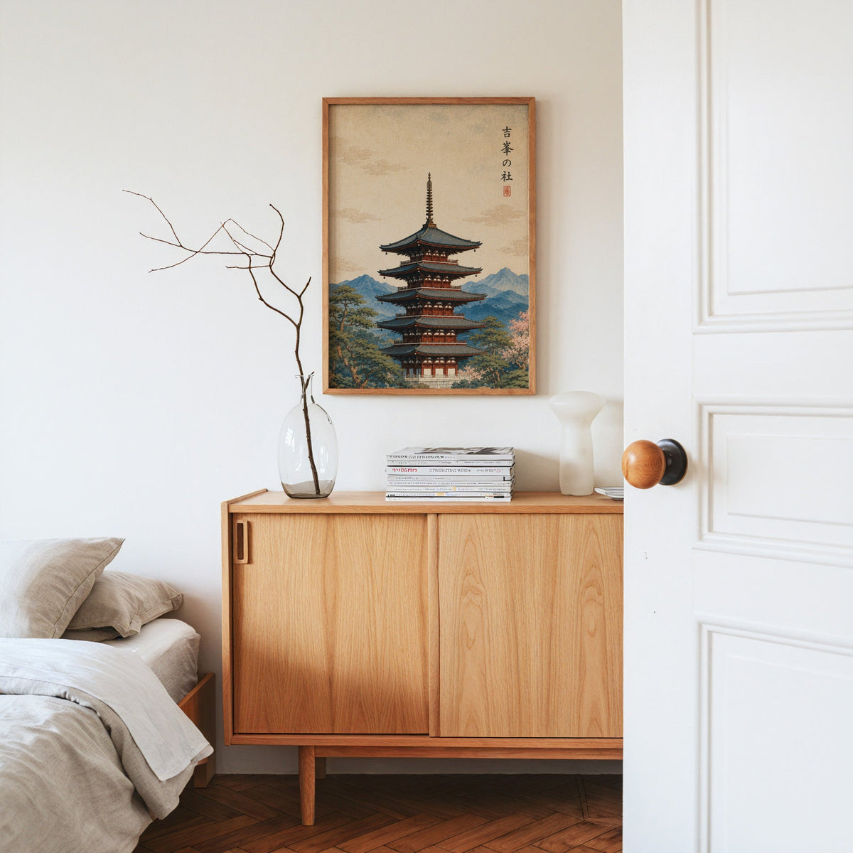 red pagoda with blue mountains print in an oak frame above an oak sideboard in a bedroom with linen bedding