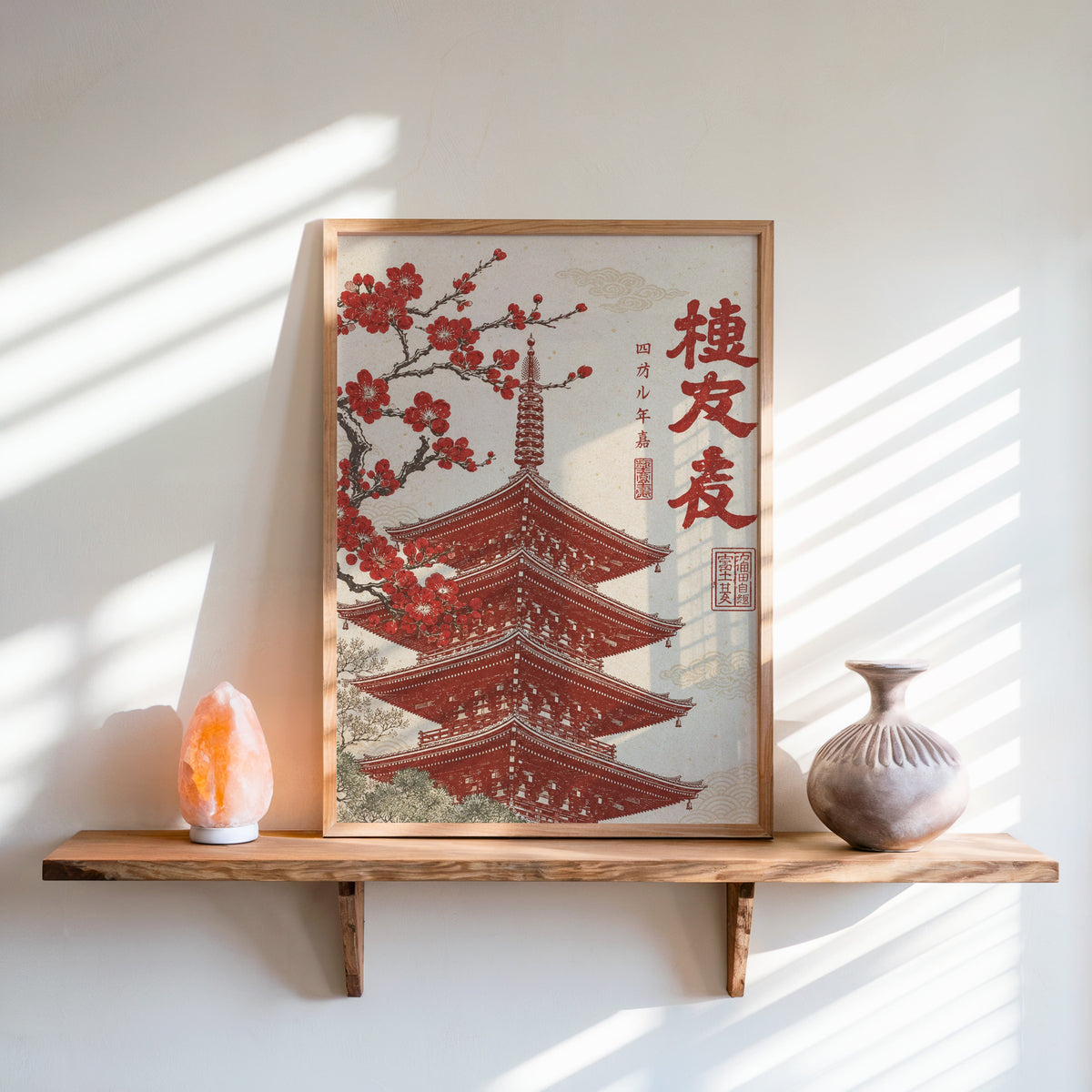 red engraved pagoda with blossom branch print in an oak frame on a live-edge wall shelf with a salt lamp and clay vase