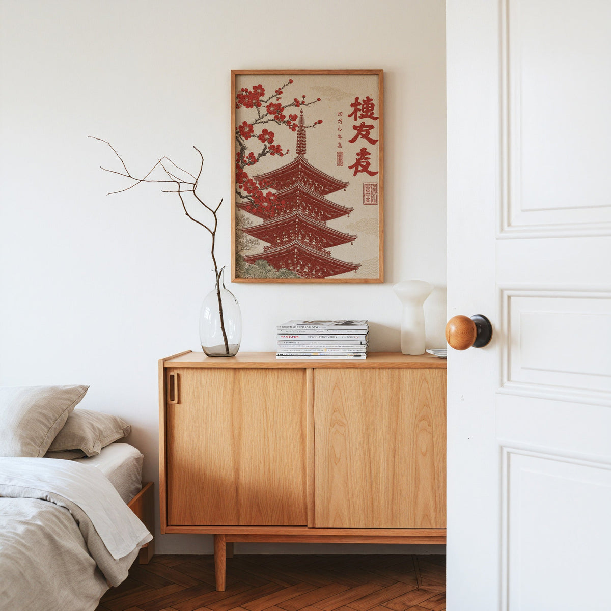 red engraved pagoda with blossom branch print in an oak frame above an oak sideboard in a bedroom with linen bedding