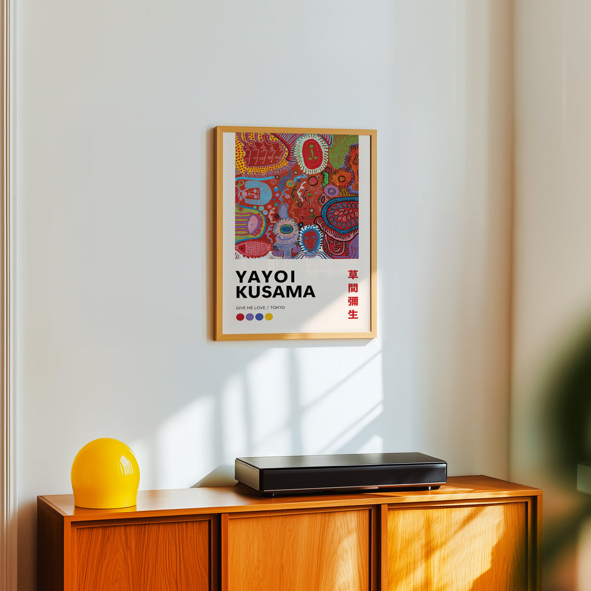 Yayoi Kusama inspired red psychedelic faces print above a sideboard with a yellow lamp