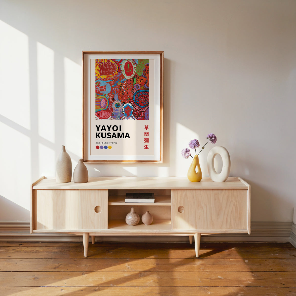 Yayoi Kusama inspired red psychedelic faces print above a pale wood console