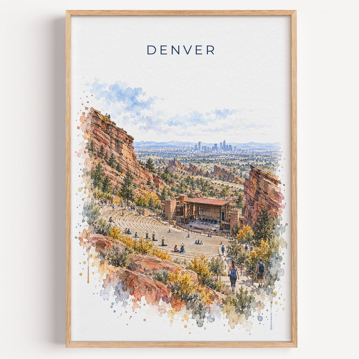 Red Rocks Amphitheatre watercolor print in a light oak frame on a plain white wall