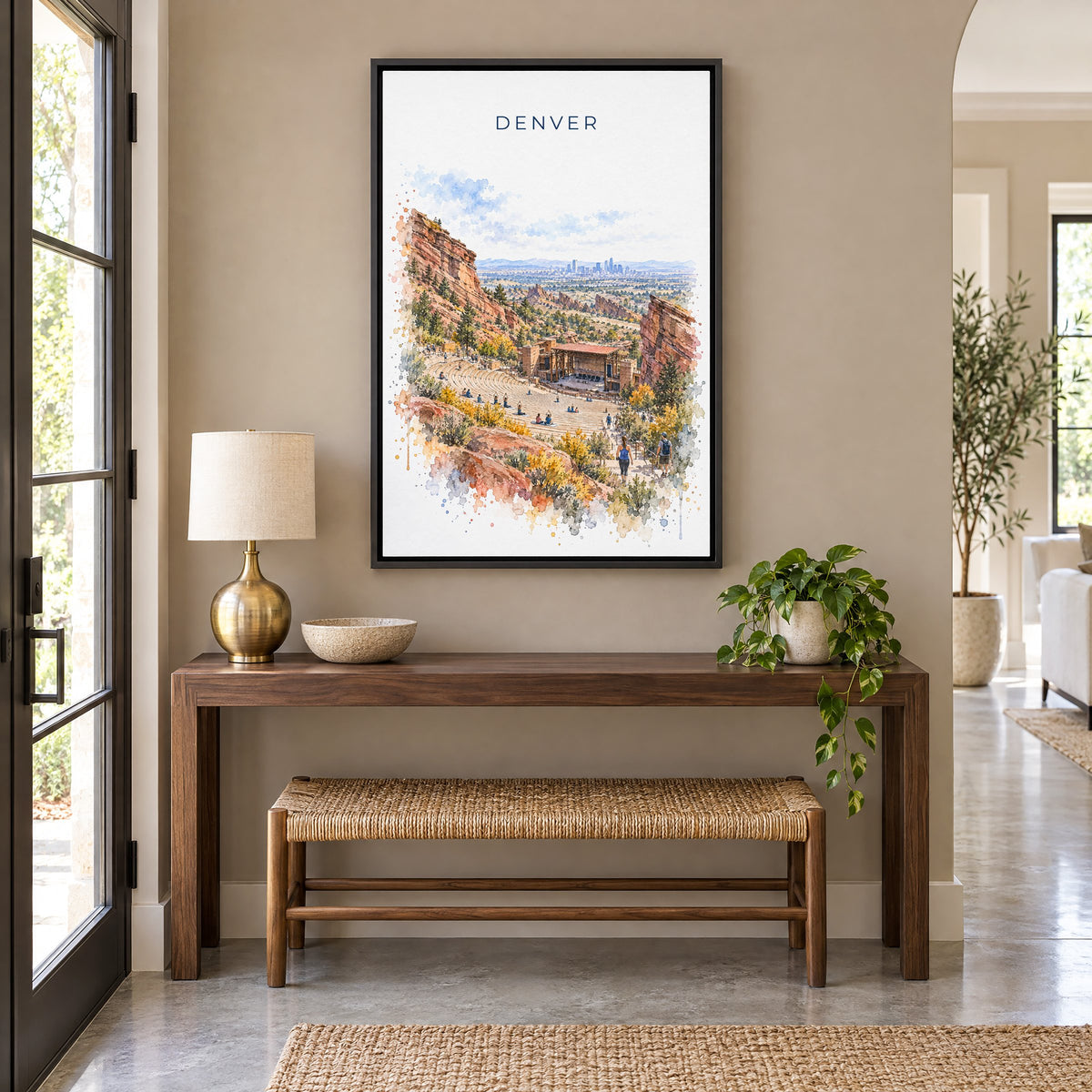 Red Rocks Amphitheatre watercolor print as a black floater canvas above a walnut console and woven bench in an entryway