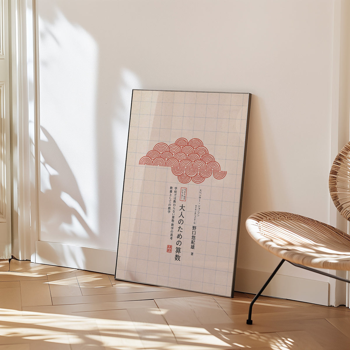 red seigaiha cloud on grid paper print in a black frame leaning on a herringbone floor beside a woven rattan chair