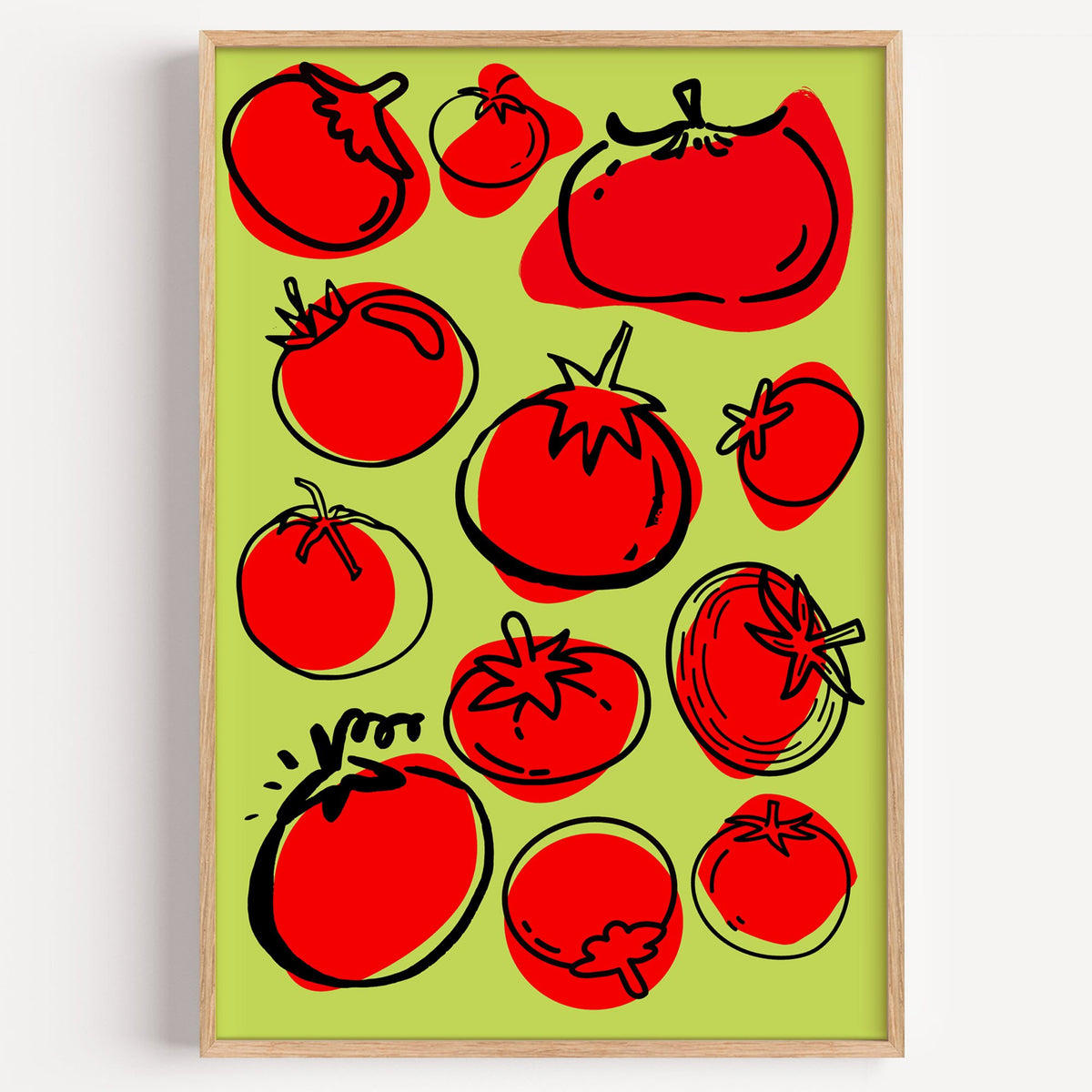 Red tomatoes on lime green print in a light oak frame on a plain white wall