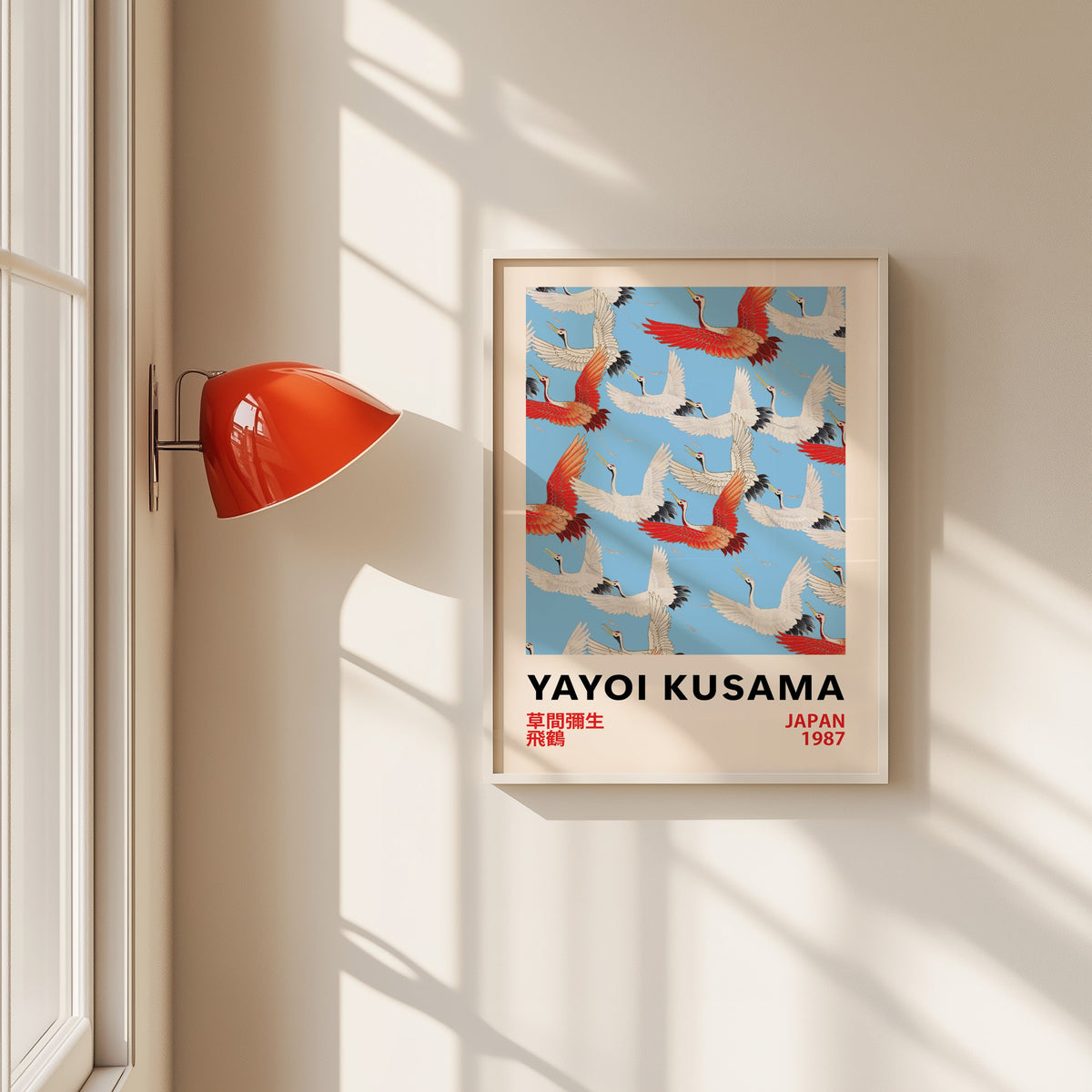Yayoi Kusama inspired red and white flying cranes print in a white frame beside a red wall sconce