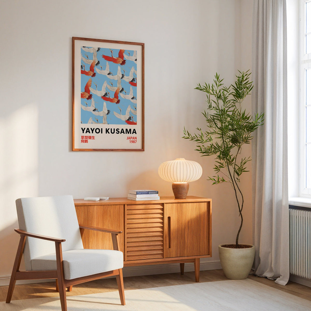 Yayoi Kusama inspired red and white flying cranes print in an oak frame above a mid century sideboard