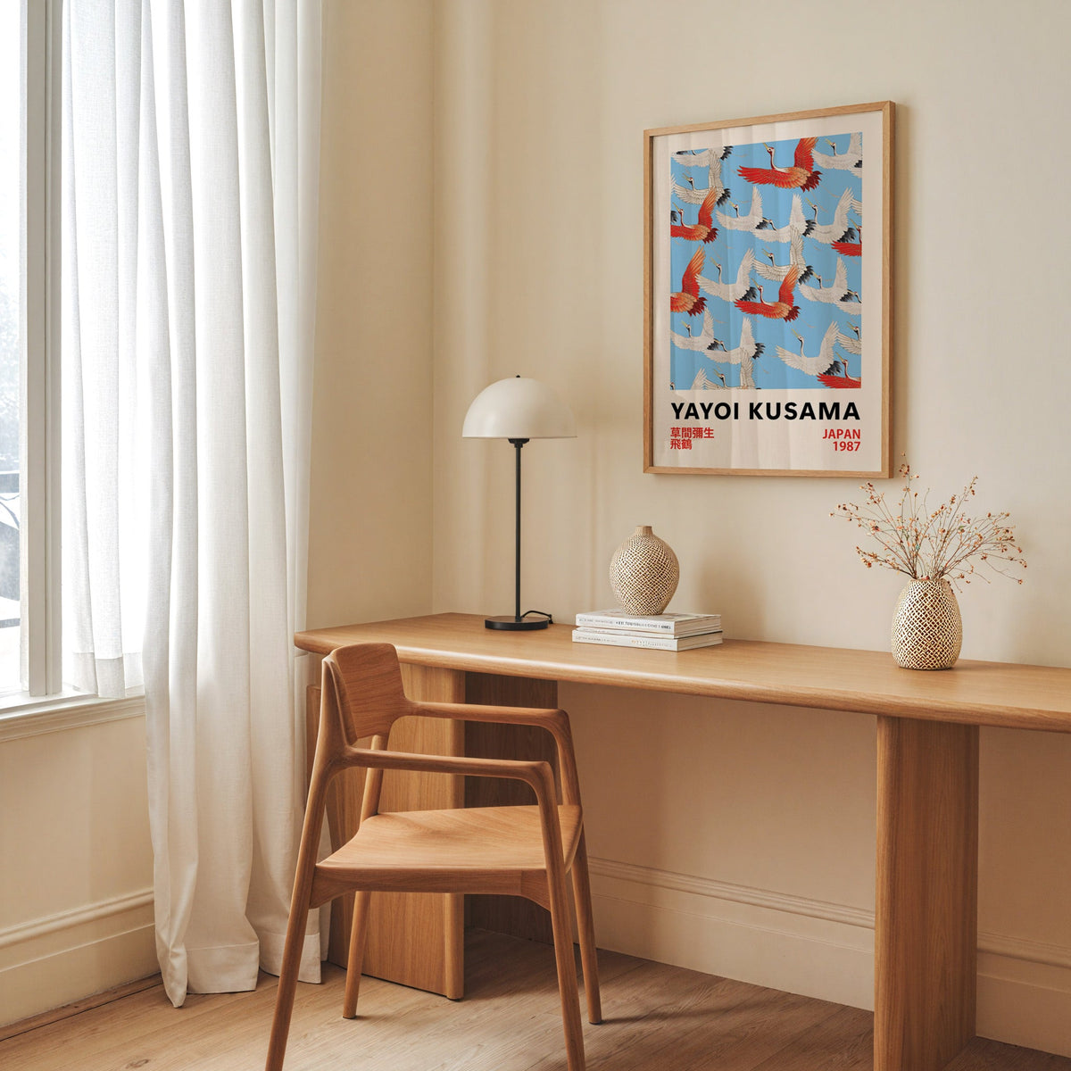 Yayoi Kusama inspired red and white flying cranes print in an oak frame above an oak desk with a dome lamp