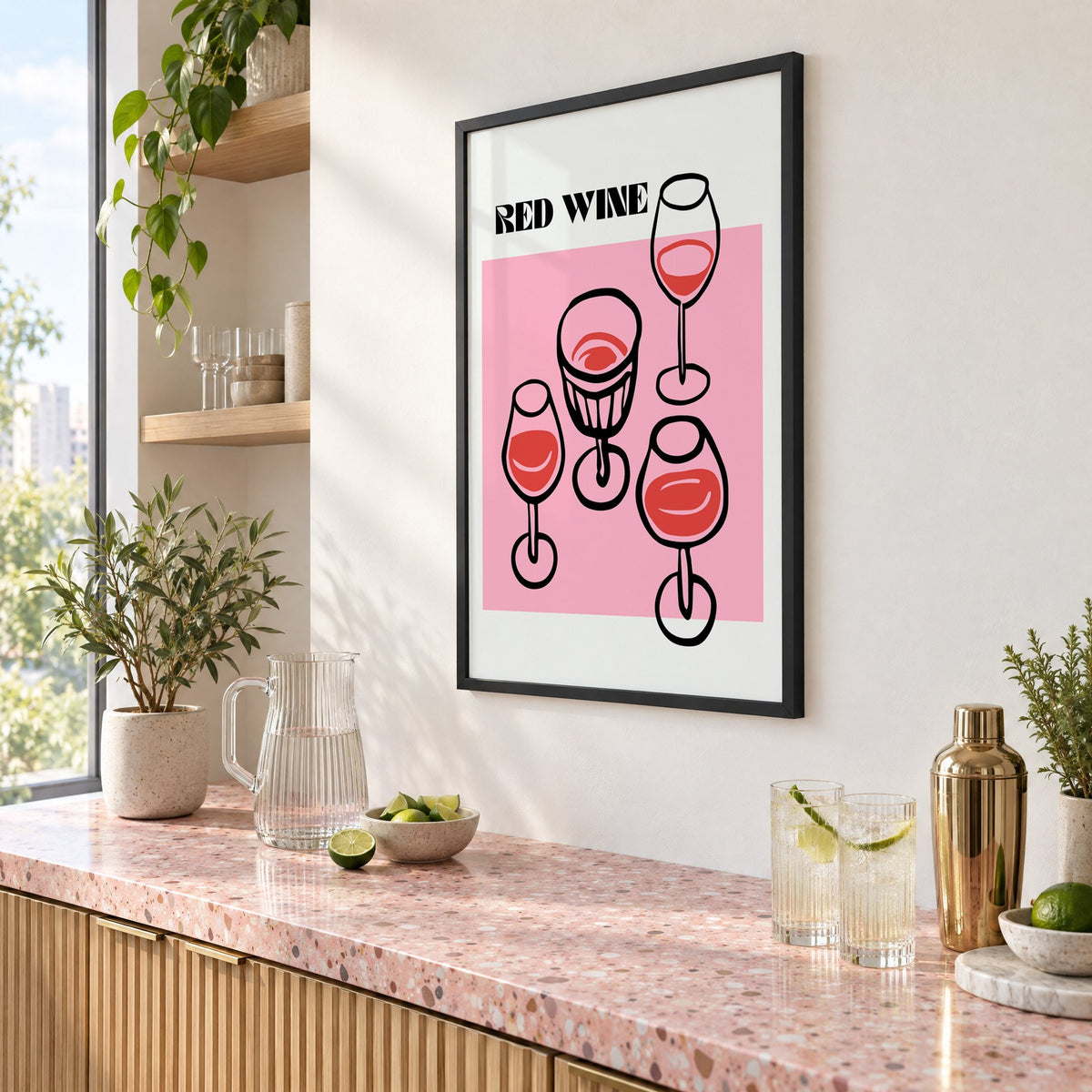 RED WINE four glasses pink print in a black frame above a pink terrazzo cocktail counter with limes, seen at an angle