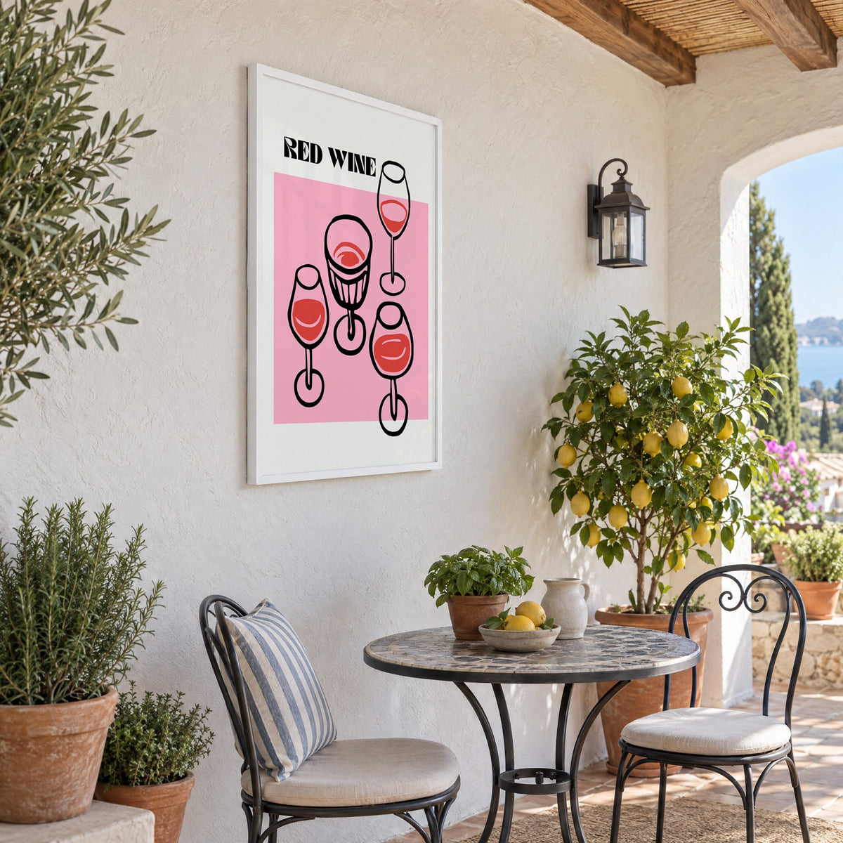 RED WINE four glasses pink print in a white frame on a sunny patio wall beside a potted lemon tree