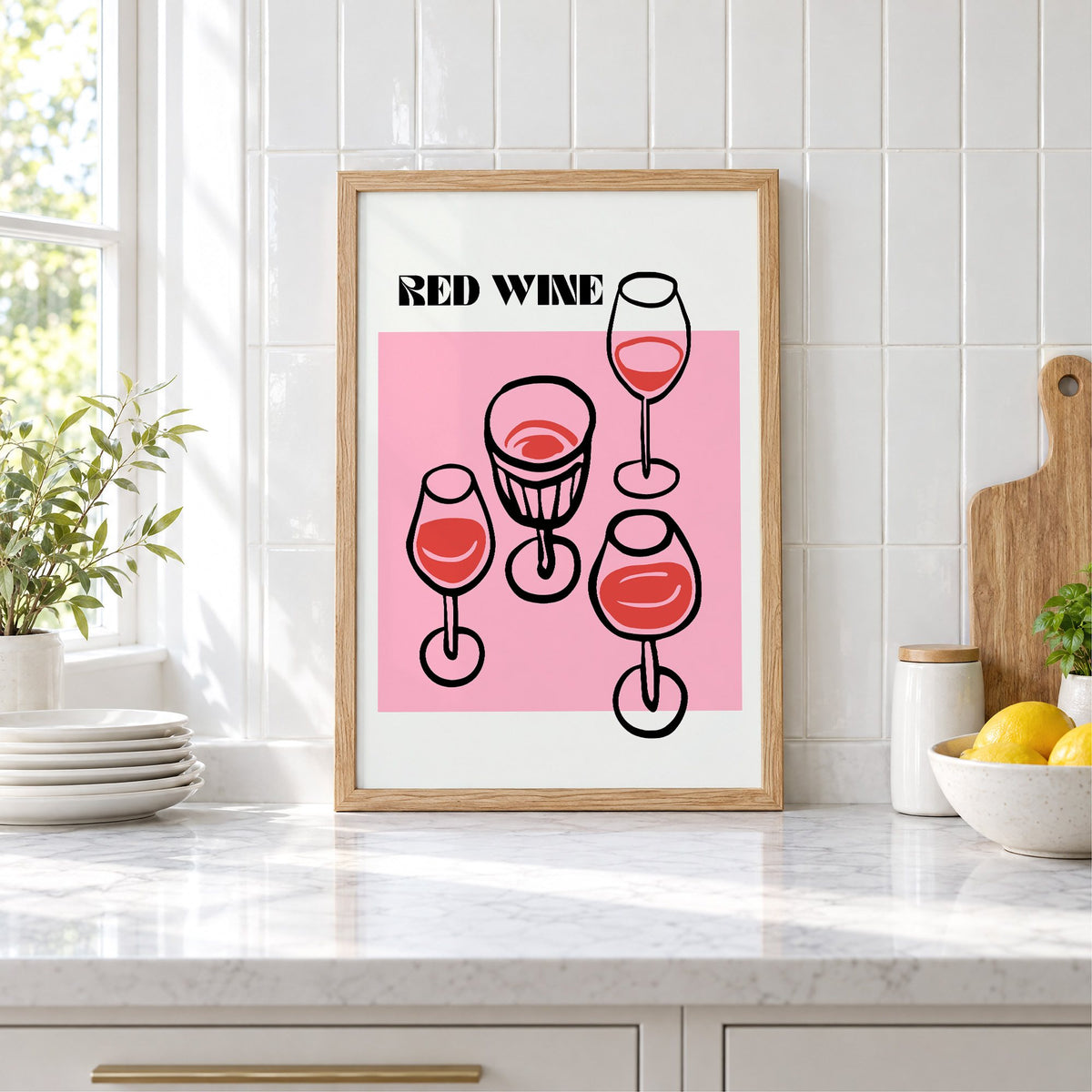 RED WINE four glasses pink print in an oak frame leaning on a marble counter by white tiles and lemons