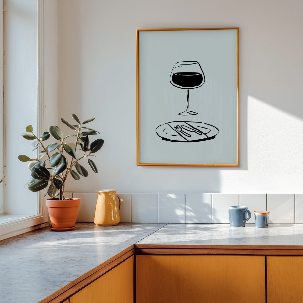 Red wine glass print in a gold frame above a marble counter with a yellow ceramic jug