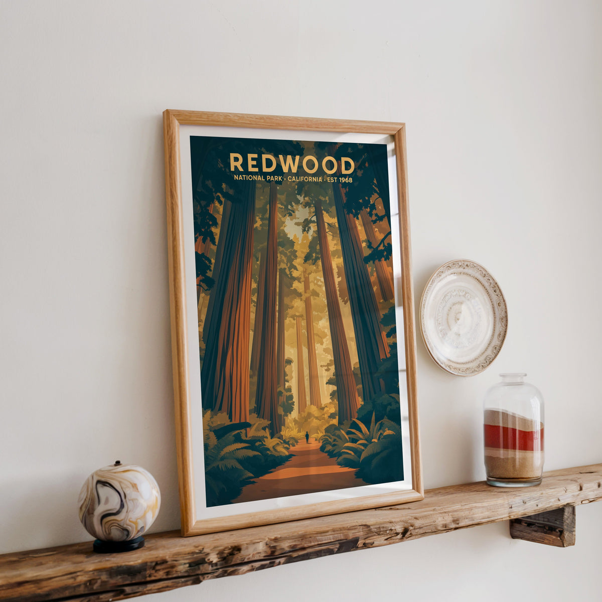 Redwood National Park print in an oak frame on a rustic wood shelf with ceramics and a sand-filled jar
