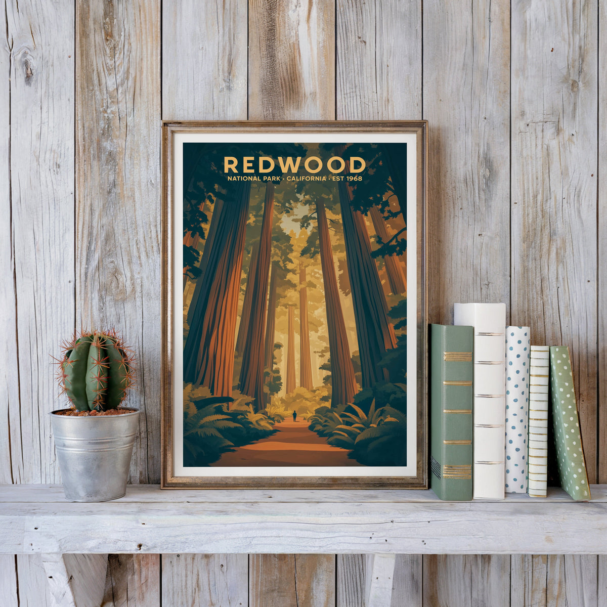 Redwood poster in an antique gold frame against whitewashed farmhouse planks beside books and a cactus