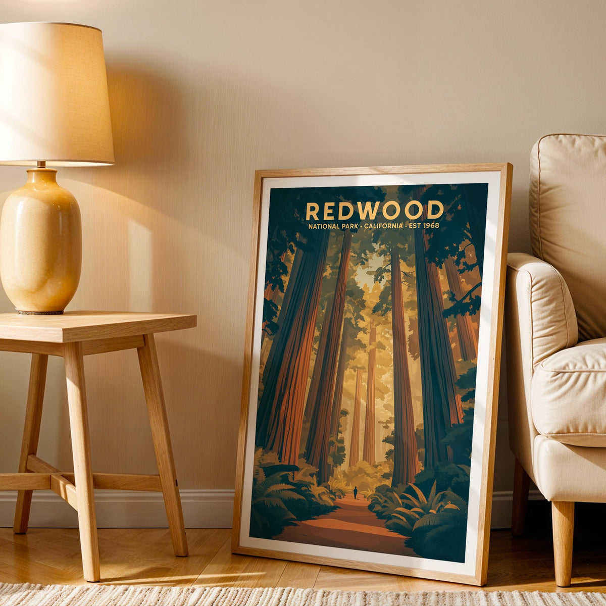 Redwood print in an oak frame beside a cream armchair and an amber lamp in warm afternoon light